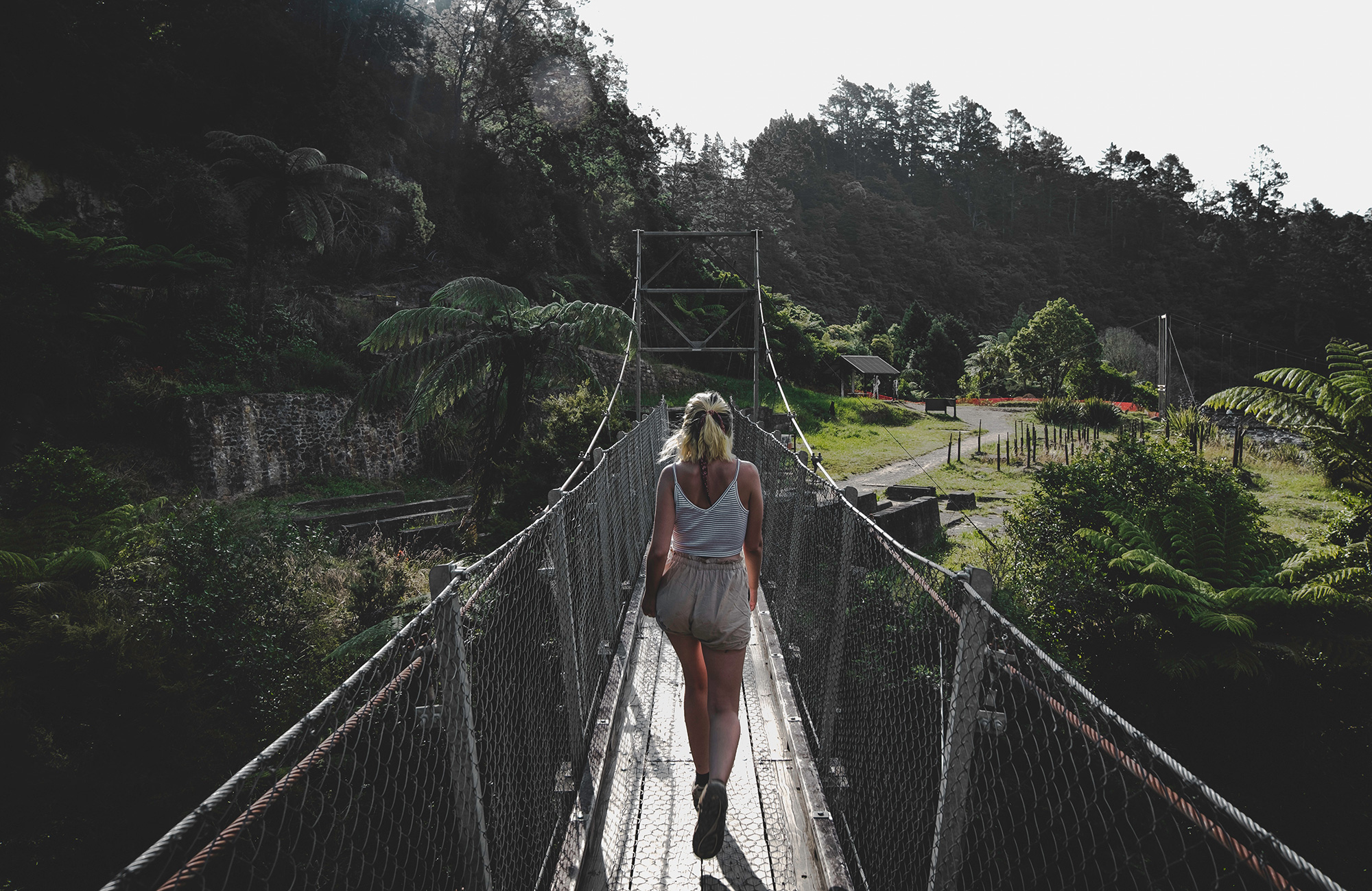 trekking-female-crosses-bridge-cover