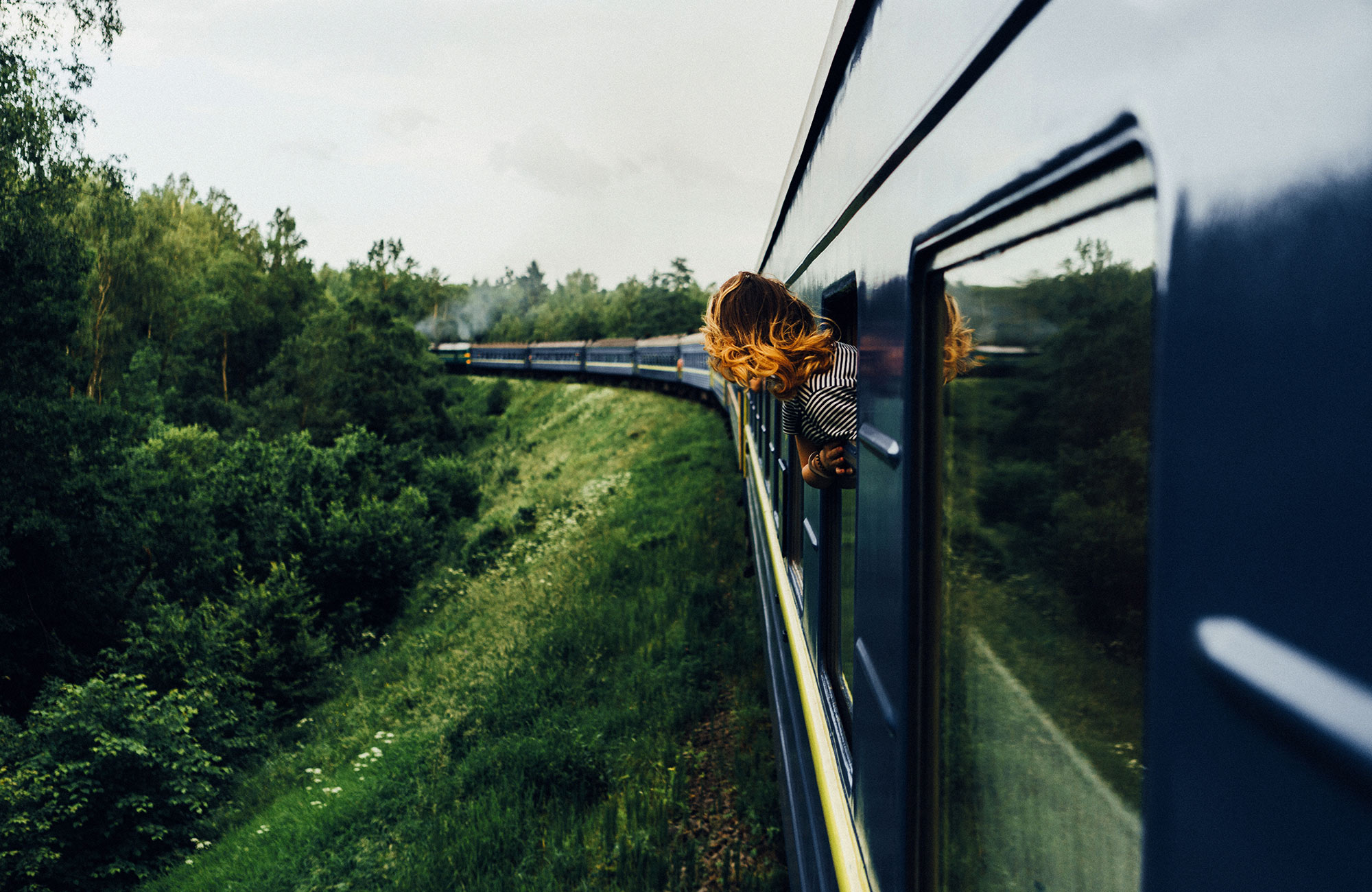 Kona í lestarferð að horfa út um gluggann í lest í Asíu