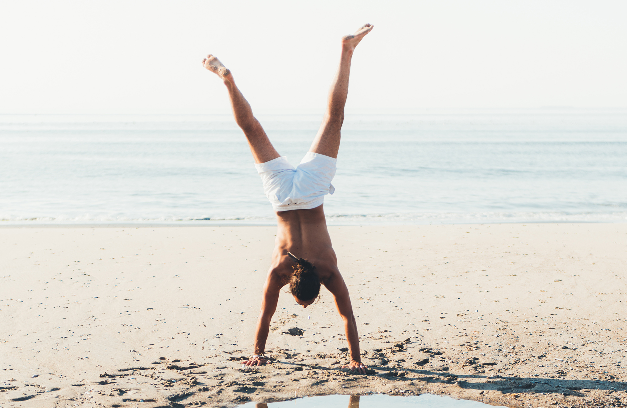 fitness-man-doing-a-handstand-beach-cover