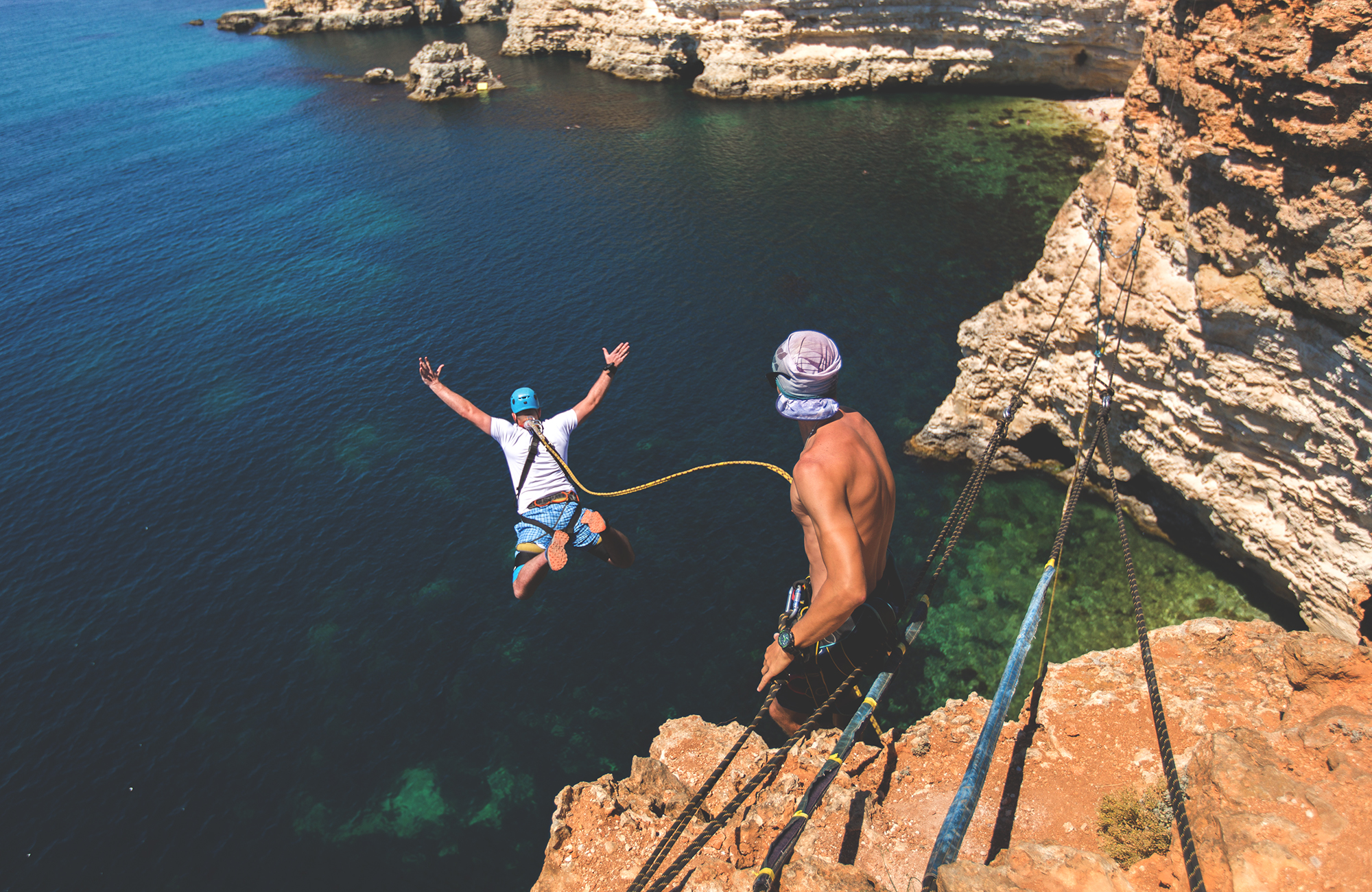Maður í orkumiklu fríi að hoppa framan a kletti