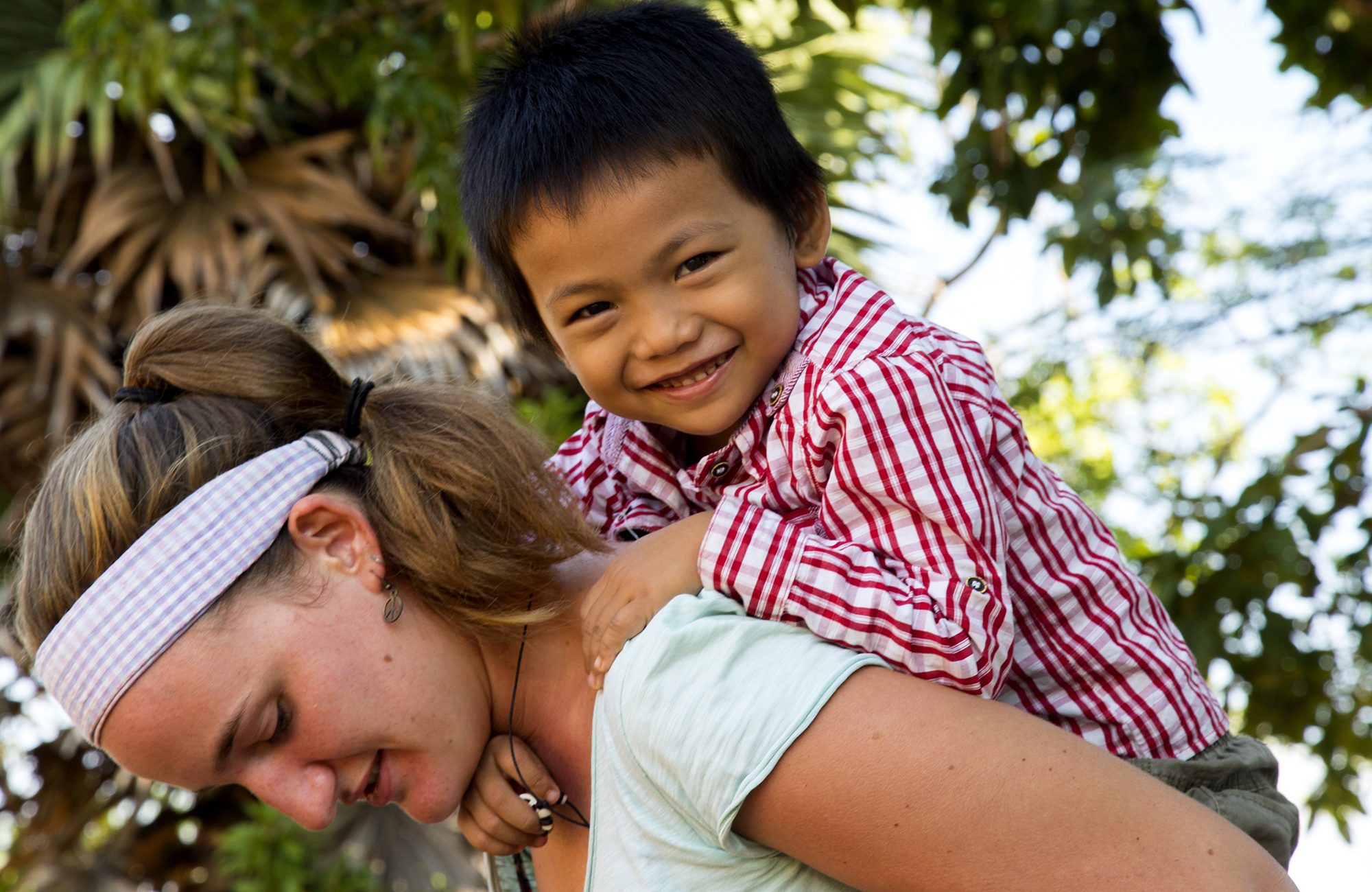 Kona með strák á hestbak í sjálfboðastarfi