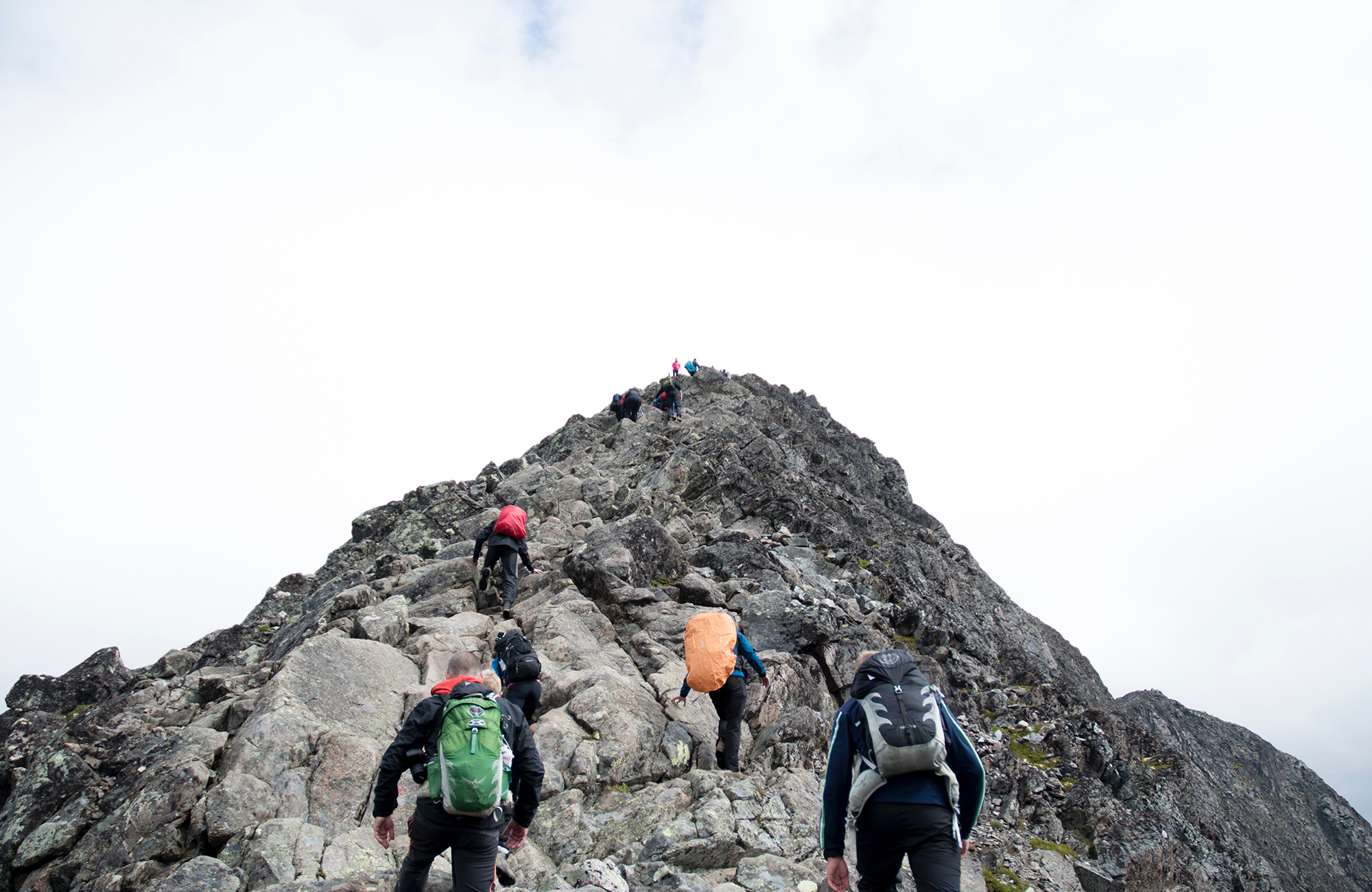 Menn í sérsniðinni hópferð að klifra upp fjall