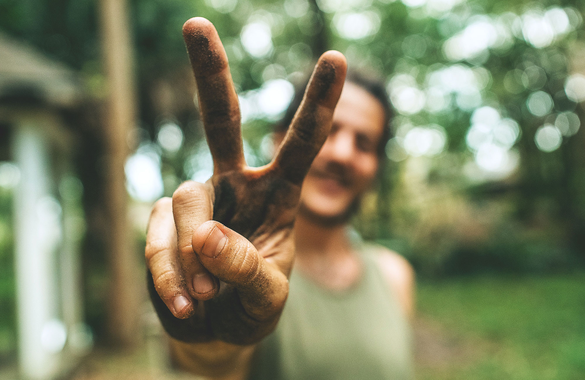 Maður að gefa myndavélinni peace merkið