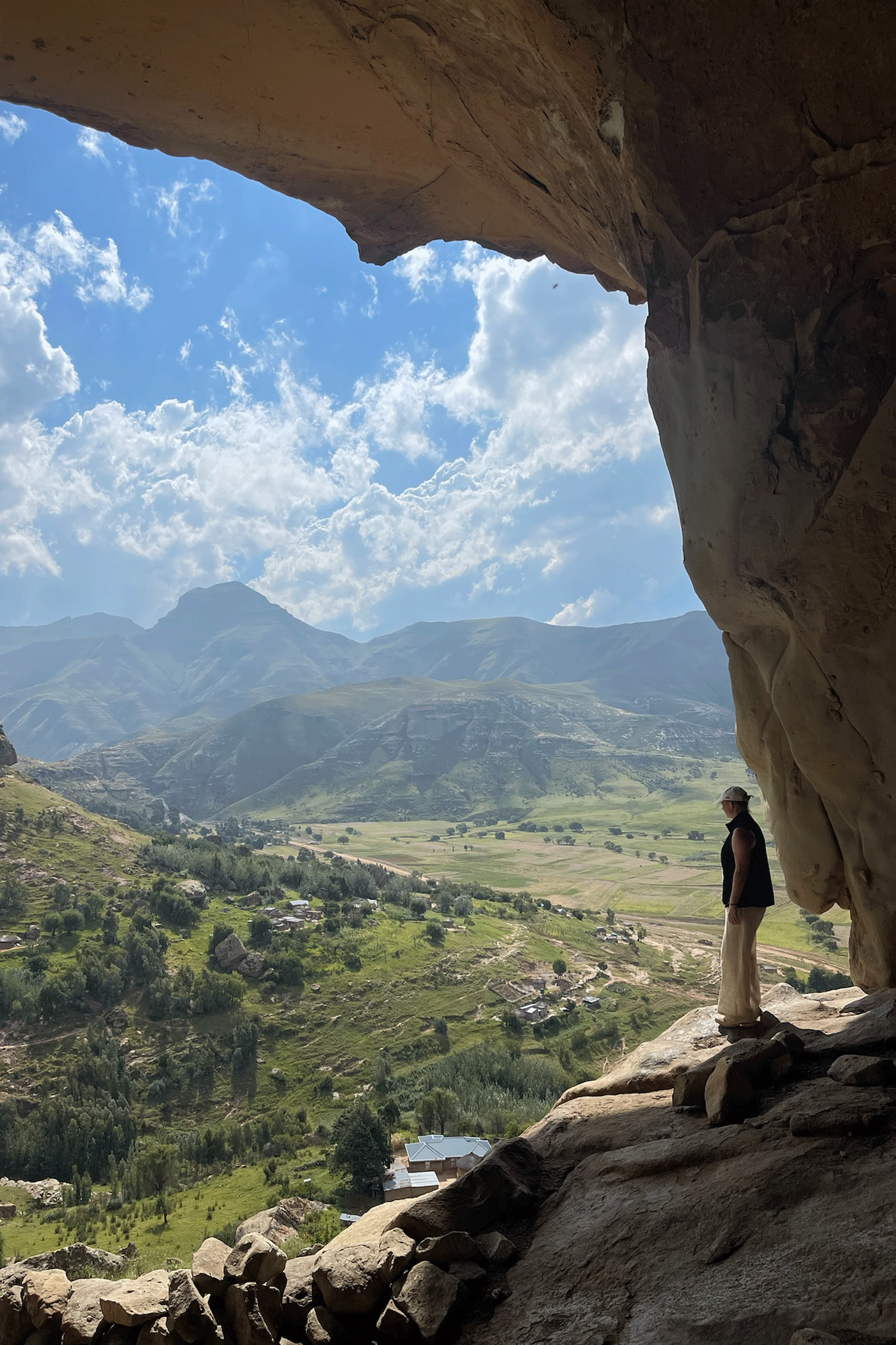 stelpa að horfa yfir grænu fjöllin í Lesotho í suður afríku